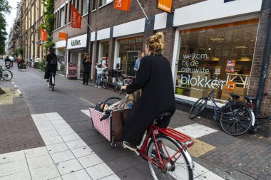 Amsterdam, Hollanda - 8 Eylül 2018: Bir anne ve iki çocuğu bisikletle eski Amsterdam, Hollanda 'da