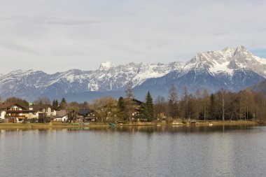Küçük bir köye doğru bakıyordu, evleri ve küçük tekneleri olan, karla kaplı dağları olan bir köye..