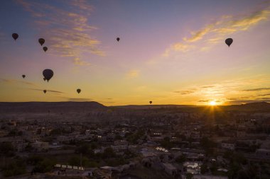 Türkiye 'nin başkenti Kapadokya' da gün doğumunda havalanan balon siluetleri şafakta yükselen balonlarla birlikte güneş doğuyor. Türkiye 'nin Genome kentindeki mağara otellerinden yükselen balonlarla şafak vakti karanlık gökyüzünden aydınlık geliyor..
