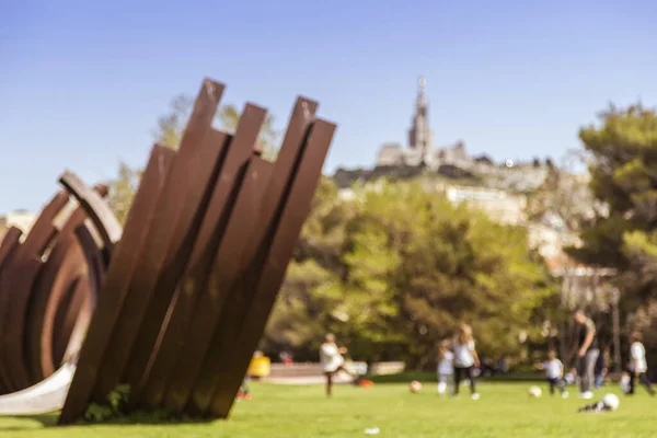 Bulanık arkaplan - Kilometrelerce Duclaux Park Basilique Notre-Dame de la Garde ve güneşin altında top oynayan çocuklar