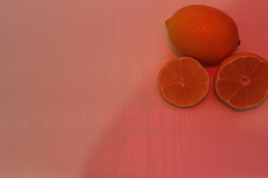 Pembe arka plandaki limonlar. Mor arka planda sulu limon