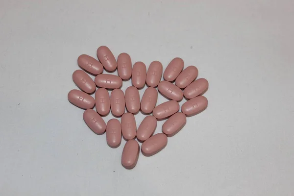 Serce Niebieskich Brązowych Tabletek Serce Wykonane Różnych Kolorowych Tabletek Wyizolowanych — Zdjęcie stockowe