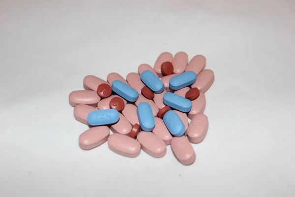 心臓は青と茶色の錠剤で作られました 異なる色の錠剤で作られた心臓は白に隔離された テキスト用のコピースペース 鎮痛剤 治療薬 中毒の概念 — ストック写真