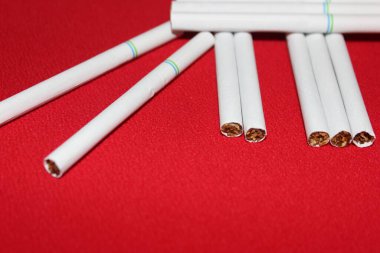 Kırmızı arka planda sigara ve mesaj için yer. Sigaralar yakın..