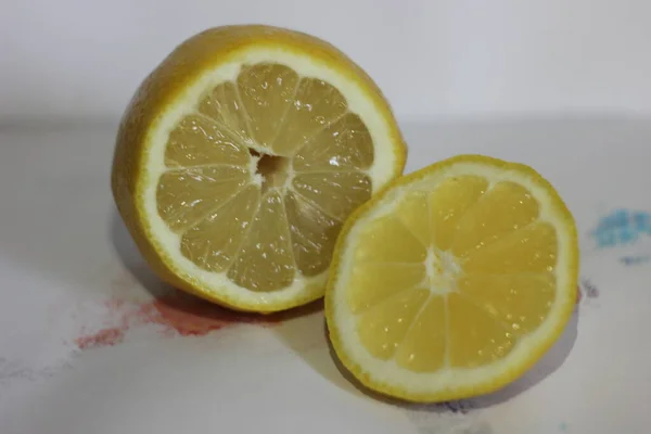 Lemons on a white background. Sliced lemon on a white table. Lemon, tangerine and orange on a white background