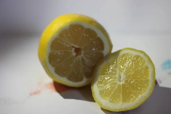 Lemons on a white background. Sliced lemon on a white table. Lemon, tangerine and orange on a white background