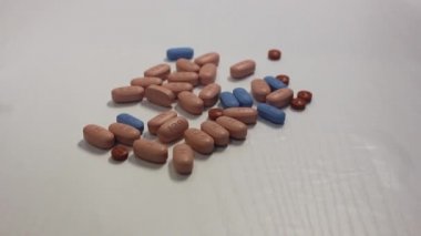 İlaçlar beyaza izole edilmiş. Uyuşturucu ve HIV 'in sosyal sorunları. Kahverengi, mavi ilaç. El hapları alır. Bir avuç dolusu uyuşturucuyla el yordamıyla.