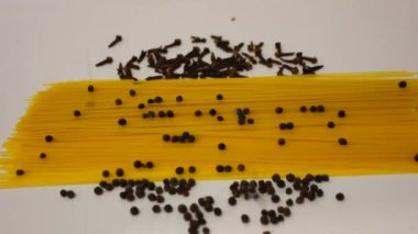Beyaz bir tabakta pişmemiş spagetti düşüyor. İtalyan spagettisi, beyaz masaya düşen İtalyan makarnası. Sadece makarna
