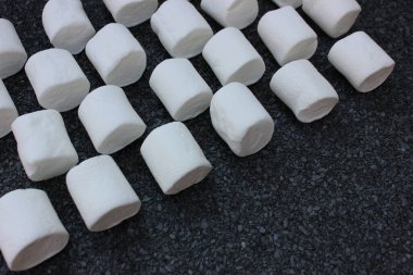 Gri taşlı arka planda şekerlemeler. Yazı için yeri olan Fonso tatlıları. Gri taşın üzerinde bir sürü beyaz, yumuşak, yumuşak, yumuşak, fotokopi alanı var.