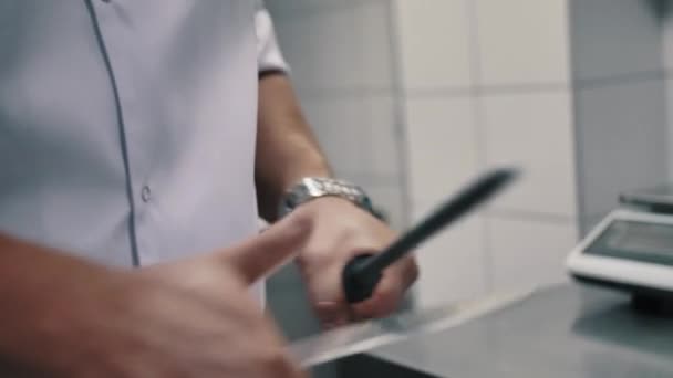 Chefe afia uma faca na cozinha — Vídeo de Stock