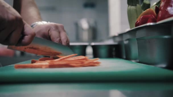 Шеф режет морковь острым ножом — стоковое видео