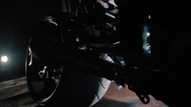 Geceleri garajda siyah bir motosikleti kıvılcımlarla kaynaştırmak.