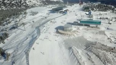 Dağların tepesinde snowboardcular ve kayakçılar