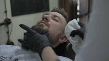 berber yüzünü havluyla siler.