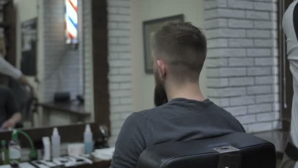 La chica barbero pone la toalla en el cliente — Vídeos de Stock