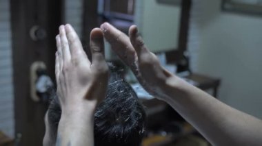 Berber bir man4 'ün stilini yapıyor.