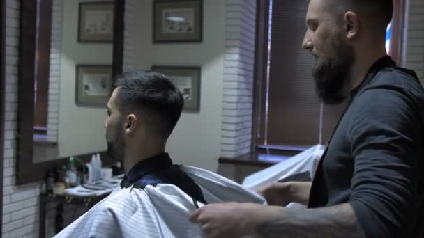 Der Friseur legt dem Kunden das Handtuch — Stockvideo