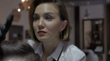 Berber kız saç kesimini bitirdi ve tatmin oldu.