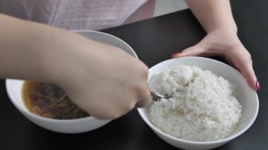 the girl takes a spoonful of rice