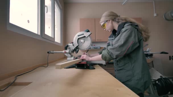 Chica en un taller aserrando materiales de madera — Vídeos de Stock