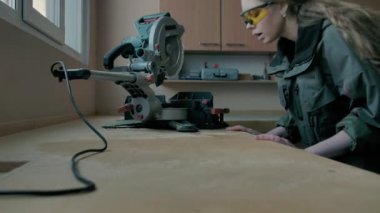 Kız masadan talaş üflüyor.