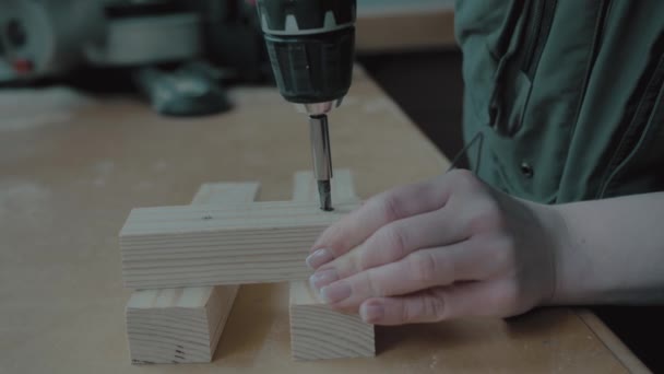 Дівчина з манікюром перекручує викрутку в дерев'яну заготовку — стокове відео