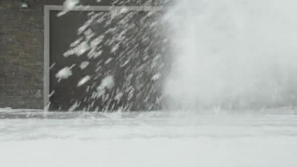 Man cleans snow with a snow thrower right to left — Stock Video