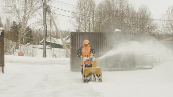 Man cleans snow with a snow thrower. Movement on camera — Stock Video