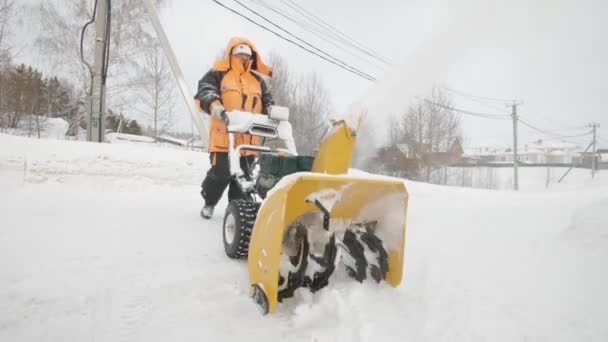 L'uomo pulisce la neve con un lancianeve — Video Stock