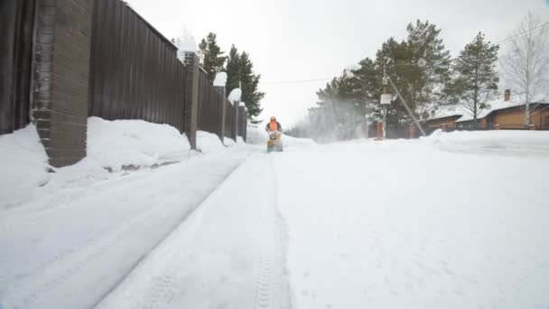 Человек чистит снег метателем снега — стоковое видео