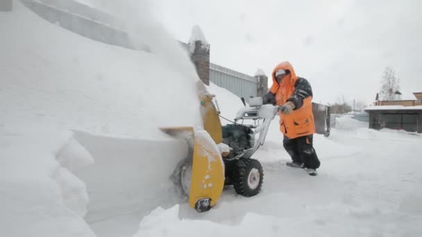 Man cleans snow with a snow thrower. Pushing mashine — Stock Video