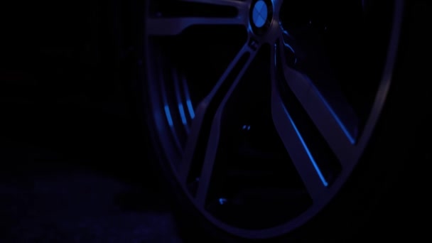 ТОМСК, РОССИЯ - 26 июля 2019 г.: Крупный план колес BMW 7 серии, черный фон. Цветное освещение . — стоковое видео