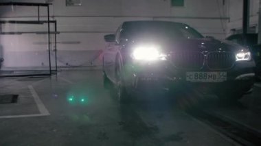 TOMSK, RUSSIA - July 26, 2019: Black BMW 7 Series drives into the garage. Adaptive LED optics.
