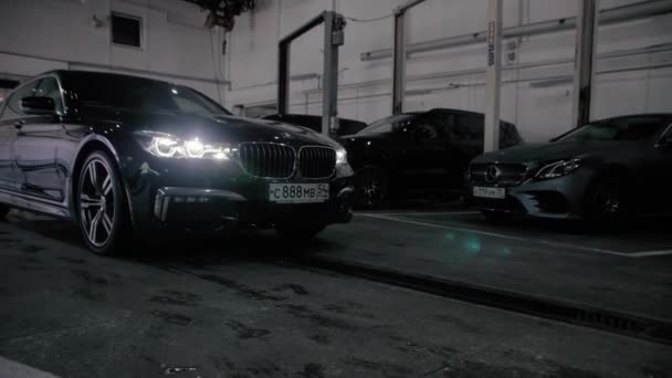 TOMSK, RUSSIA - July 26, 2019: Black BMW 7 Series drives into the garage. Adaptive LED optics. — Stockvideo