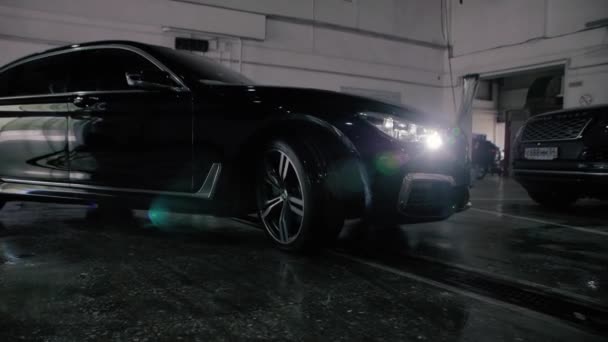 TOMSK, RUSSIA - July 26, 2019: Black BMW 7 Series drives into the garage. Adaptive LED optics.
