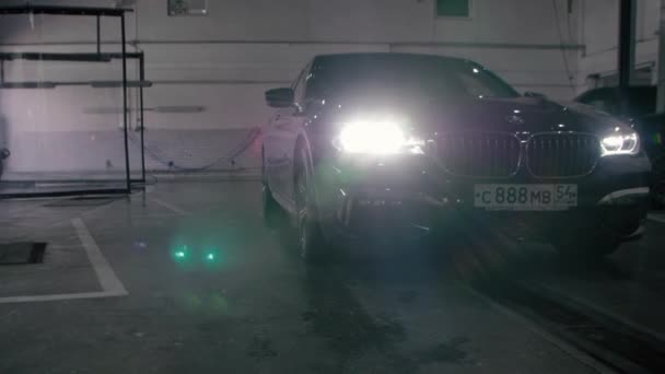 TOMSK, RUSIA - 26 de julio de 2019: Black BMW 7 Series conduce al garaje. Óptica led adaptativa . — Vídeo de stock