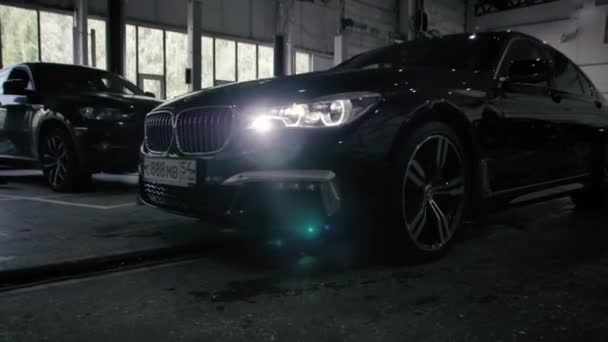 TOMSK, RUSIA - 26 de julio de 2019: Black BMW 7 Series conduce al garaje. Óptica led adaptativa . — Vídeo de stock