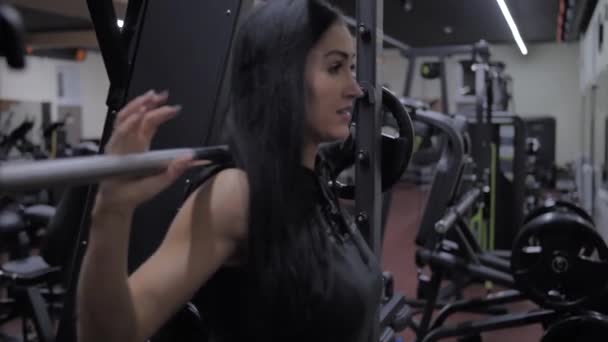Atletisch sexy meisje is voorbereiding naar zitten in de simulator smid — Stockvideo