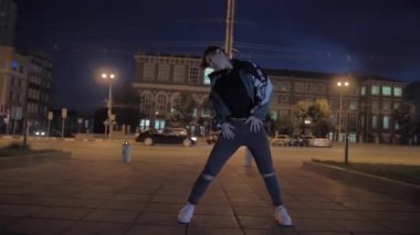 Çok şık Asyalı bir kız gece bir şehir caddesinde dans ediyor. Etkileyici Koreli kız.
