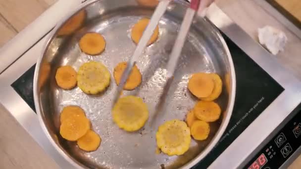 Freír zanahorias y maíz en una sartén vista superior — Vídeo de stock