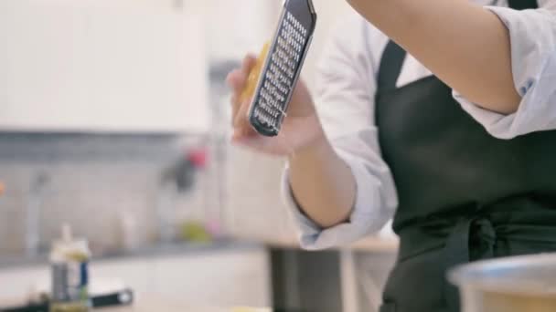 La ragazza sta strofinando il formaggio olandese su una grattugia per i ravioli — Video Stock