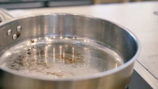 Оливковое масло наливают в кастрюлю тонким ручьем — стоковое видео