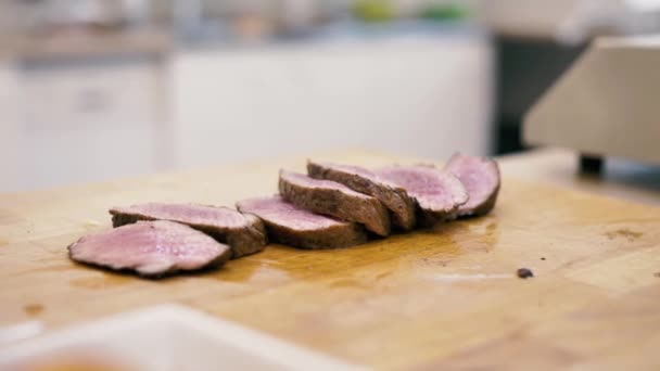 Menina chef corta bife de carne em fatias — Vídeo de Stock