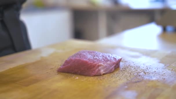 Pedaço de carne fresca é pimenta na mesa de madeira — Vídeo de Stock