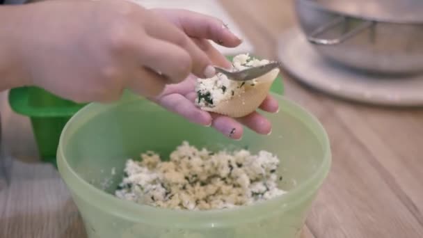 Het meisje handen zet de vulling in het deeg en het verandert Italiaanse ravioli — Stockvideo