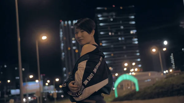 Korean girl posing at night on the street against the background of skyscrapers — Stock Photo, Image