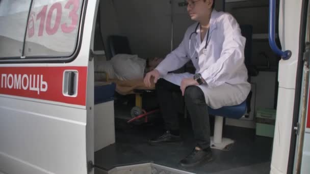 El doctor cierra la puerta de la ambulancia desde dentro. — Vídeo de stock