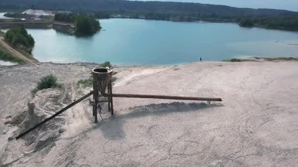 Homokgödör egy kék tóval és egy lány a szélén — Stock videók