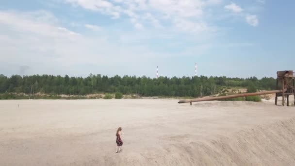 Dívka v slunečních šatech kráčí podél okraje pískoviště — Stock video