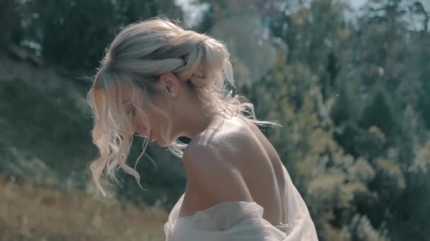 Блондинка в белом платье выпрямляет платье — стоковое видео